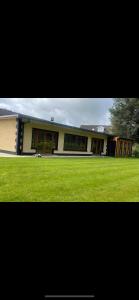 un gran edificio con césped verde delante de él en Woodland lodge green room en Dungiven