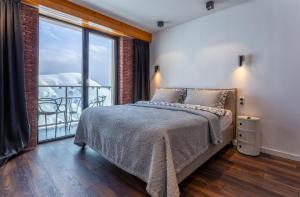 a bedroom with a bed and a large window at Gudauri Mountain Views in Gudauri
