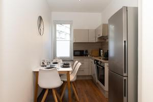 uma cozinha com uma mesa com cadeiras e um frigorífico em City Apartment am Zoo & Stadtkern em Leipzig