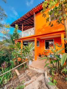 an orange house with a pathway leading to it at Casa na Floresta in Itacaré