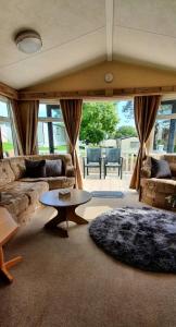 a living room with a couch and a table at Sandy Toes Hoburne Devon Bay Holiday Park. in Paignton