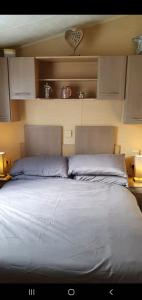 a bedroom with a large bed with two pillows at Sandy Toes Hoburne Devon Bay Holiday Park. in Paignton
