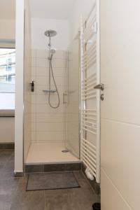 um chuveiro com uma porta de vidro na casa de banho em City Apartment am Zoo & Stadtkern em Leipzig