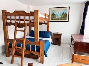um quarto com um beliche de madeira com lençóis azuis em Apartaestudio Cerca al Parque Lago em Pereira