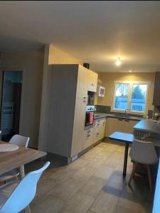 une grande cuisine avec une table et une table et des chaises dans l'établissement Petit nid douillet mitoyen à Auterive, à Auterive 8 autres photos