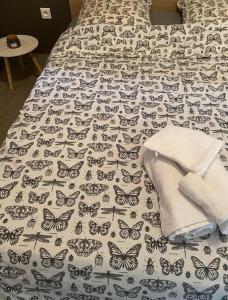 łóżko z narzutą z motylami w obiekcie Appartement mitoyen avec terrasse w mieście Auterive