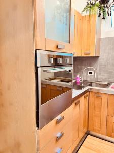 La cuisine est équipée d'armoires en bois et d'un réfrigérateur en acier inoxydable. dans l'établissement BB SAN SIRO, à Milan