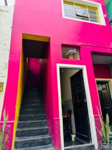 a pink building with stairs in front of it at Maison Verte - Budget Edition in Arequipa