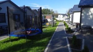 a backyard with a trampoline in the grass at Domki Fio in Sarbinowo