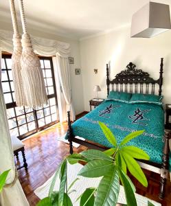 a bedroom with a bed with a green comforter at Spray B&B Sitio in Nazare, European style in Nazaré