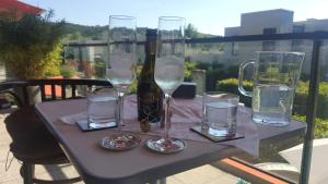 a table with glasses and a bottle of water on it at sonniges Appartement in Mariatrost in Graz