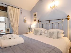 ウィンダミアにあるCharlottes Cottageのベッドルーム1室(大型ベッド1台、白いシーツ、枕付)