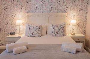 a bedroom with a large white bed with two lamps at Bridgeside Rooms in Ironbridge