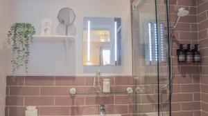 a bathroom with a shower and a sink with a mirror at Bridgeside Rooms in Ironbridge