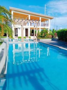 une piscine devant une maison dans l'établissement Coho The Hermosa - Staycation Studio Unit and Balcony View with Swimming Pool and Open Court access, à Manille