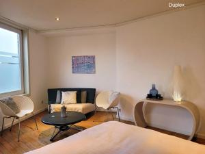 ein Schlafzimmer mit einem Bett, einem Sofa und einem Tisch in der Unterkunft Duplex Apartment in Varsenare