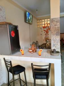 a kitchen counter with two chairs and a refrigerator at Villa Bella Copacabana in Copacabana