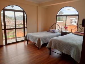 Duas camas num quarto com janelas grandes em Villa Bella Copacabana em Copacabana