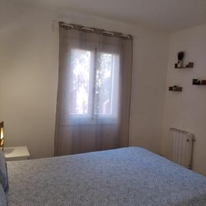 a bedroom with a bed and a window at Es Niuet in Cala Galdana
