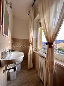 a bathroom with a sink and a tub and a window at Affittacamere La Dimora dei Nonni in Cascia