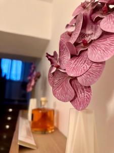 uma flor rosa num vaso branco sobre uma mesa em Affittacamere La Dimora dei Nonni em Cascia