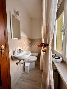 a bathroom with a sink and a toilet and a mirror at Affittacamere La Dimora dei Nonni in Cascia