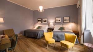 a bedroom with two beds and a table and chairs at Santa Chiara Boutique Hotel in Naples