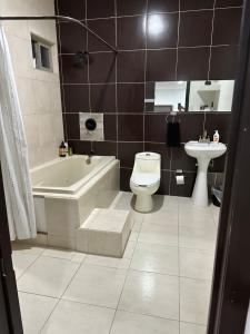 a bathroom with a toilet and a tub and a sink at Deliciosa Escapada de la Rutina in San Luis Río Colorado