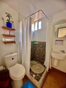 uma casa de banho com um WC e um chuveiro de pedra. em Tayrona Angel Lodge em El Zaino