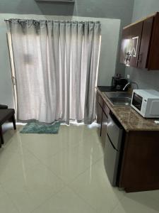 a kitchen with a window with a sink and a microwave at Deliciosa Escapada de la Rutina in San Luis Río Colorado +8 photos