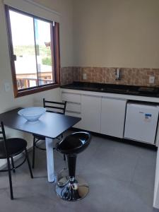 a kitchen with a table and chairs and a window at TEMPO FLATS E HOSPEDAGEM in Alto Paraíso de Goiás