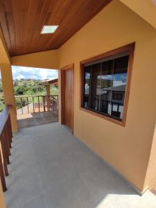 a room with a large window and a balcony at TEMPO FLATS E HOSPEDAGEM in Alto Paraíso de Goiás