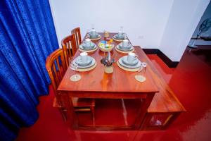 una mesa de madera con platos y platos. en Royal Homestay, en Moshi