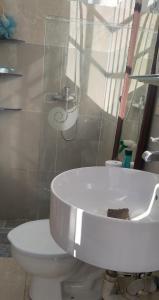 a white toilet and a sink in a bathroom at Casa familiar in Batey La Altagracia