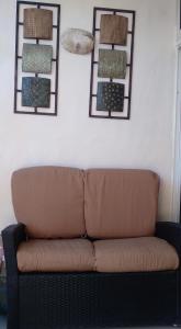 a brown couch against a white wall with two mirrors at Casa familiar in Batey La Altagracia