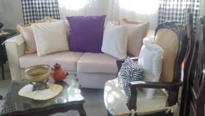 a living room with a couch and a table with pillows at Casa familiar in Batey La Altagracia