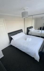 Schlafzimmer mit einem großen weißen Bett und einem Spiegel in der Unterkunft Cheerful Two Bed Home, Free Parking & Pool Table in Middlesbrough