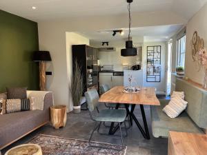 a living room with a table and a couch at It Gasthûs in Baaiduinen