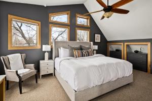 a bedroom with a bed and a ceiling fan and a chair at BoHo Oasis - Hot Tub - Peloton - Walk to Tennyson in Denver