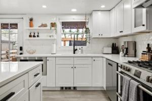 a white kitchen with white cabinets and appliances at BoHo Oasis - Hot Tub - Peloton - Walk to Tennyson in Denver