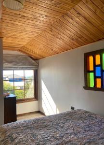1 dormitorio con cama y vidriera en Habitación privada, vista al mar 3 en Ancud