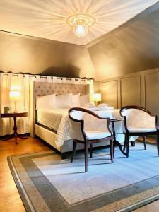 a bedroom with a bed with two chairs and a table at The Ginkgo Tree in Mount Pleasant