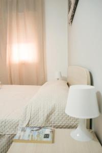 a bedroom with a bed with a table with a lamp at Rael in Cefalù