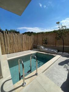 a swimming pool in a backyard with a fence at Theros Suites in Dhiminión