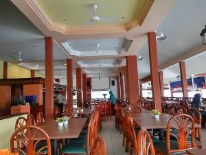 una sala da pranzo con tavoli e sedie in legno di Bukit Tinggi Fuchsia Hillhomes a Bukit Tinggi
