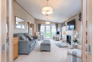 a living room with a couch and a fireplace at Stewarts Resort Lodge 18 in St. Andrews