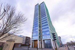 um edifício de vidro alto numa rua da cidade em Quayside Penthouse 2 BedRoom Ensuite near Media City & Manchester United em Manchester
