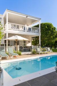 a house with a swimming pool in front of a house at Southern Cross Beach House in Plettenberg Bay