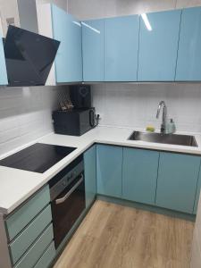 a kitchen with blue cabinets and a sink at Habitación acogedora matrimonial in Olesa de Montserrat