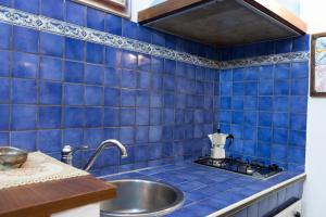 a blue tiled kitchen with a sink and a stove at Casa Vitelli - Centro Storico a due passi da tutto in Terracina